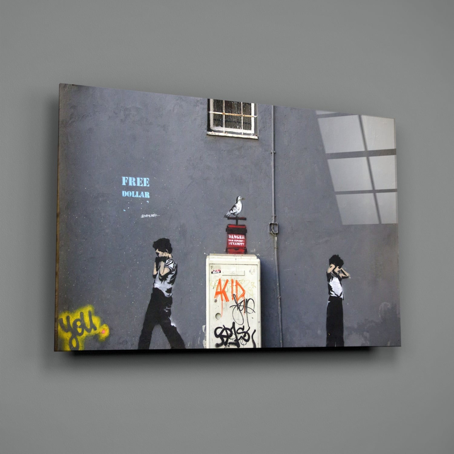 Glass art canvas displaying street art style figures, "FREE DOLLAR" text, pigeon, and utility box on gray wall with window reflection.