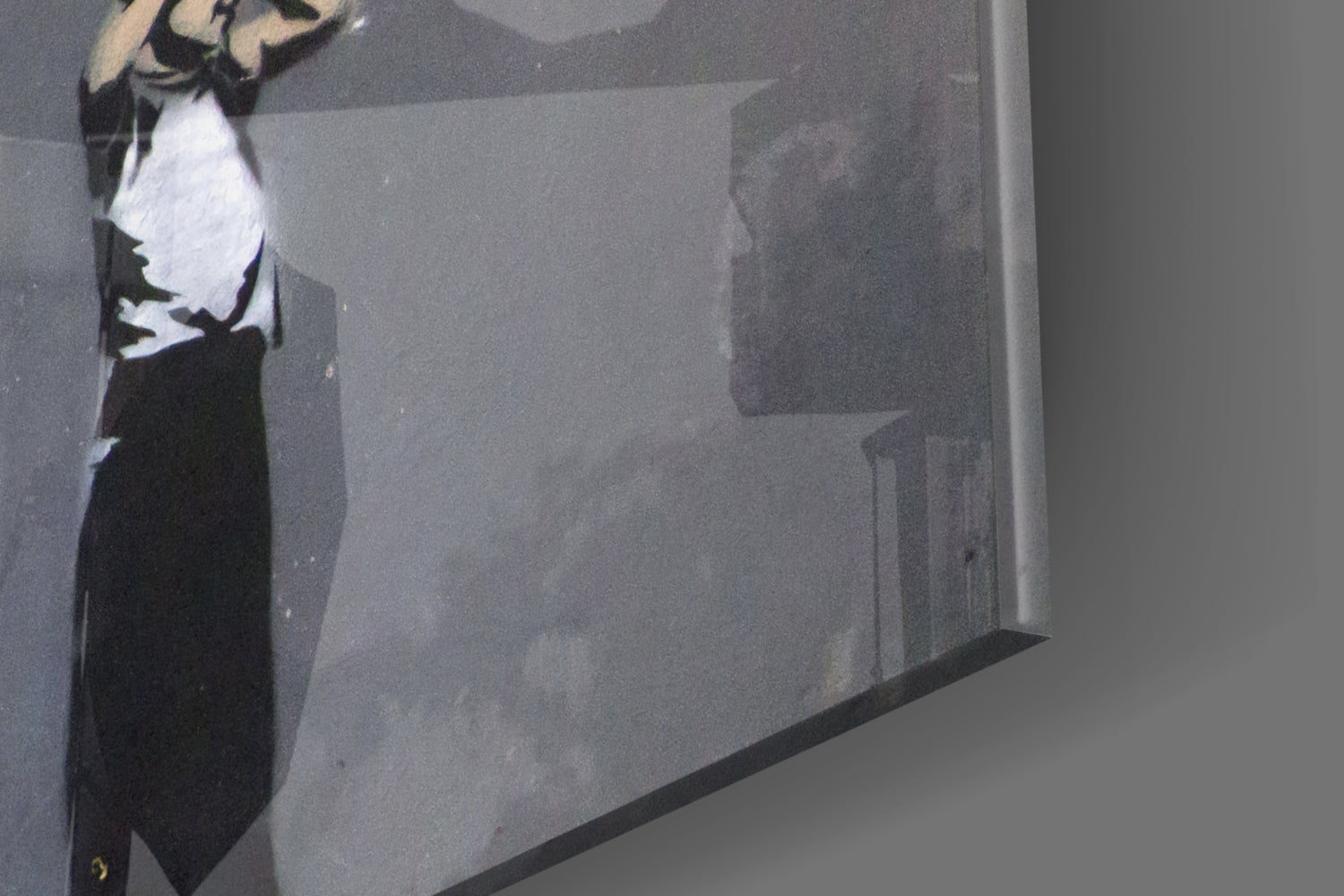 Close-up angled view of glass art showing black silhouette figure with white shirt detail against gray interior surface.