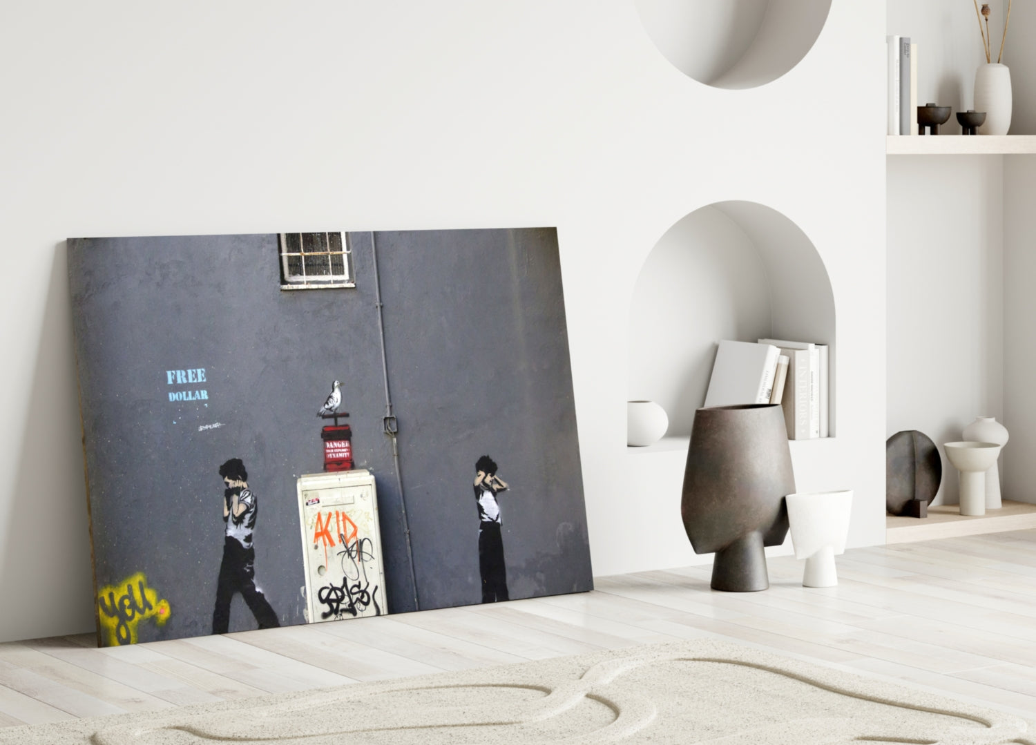 Street art glass panel leaning against white wall in minimalist interior with sand, featuring "Free Dollar" text and stenciled figures on dark background.