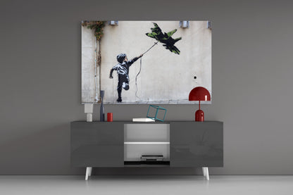 War Kite Glass Art displayed above gray media console showing child with string flying green bird against white wall.