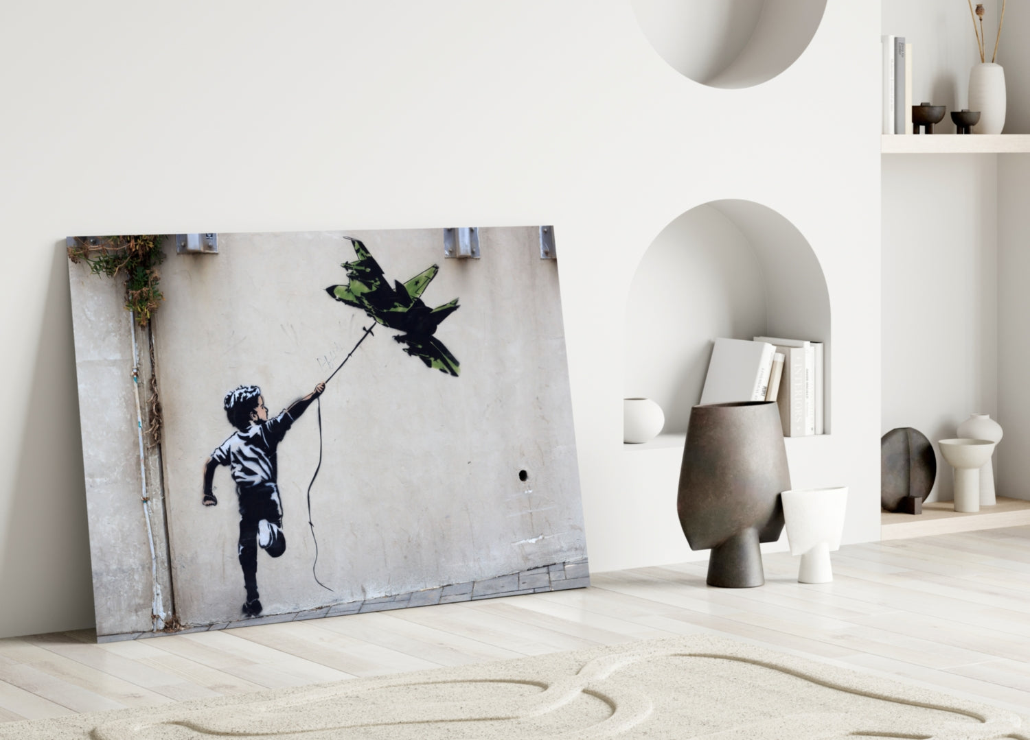 Glass art print of a child reaching upward with a string attached to a black bird silhouette, leaned against white wall in minimalist interior.