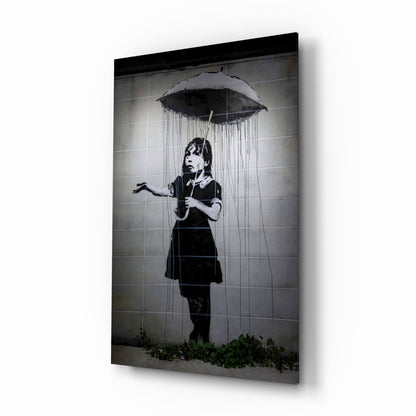 Black and white stencil art on glass panel showing child with umbrella under rain, mounted on white wall.