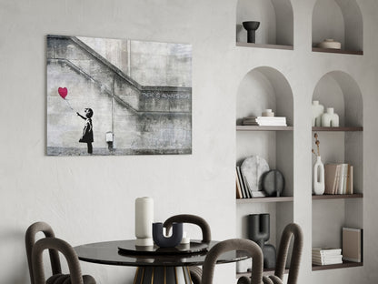 Flying Heart Glass Art canvas print displayed on white wall above dining table in minimalist interior with shelving.