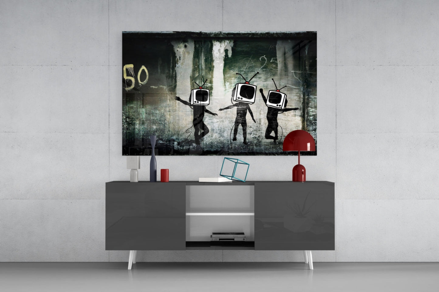 Modern living room setup with TV Heads Glass Art mounted above gray media console, featuring three figures with television screens for heads against distressed urban background.