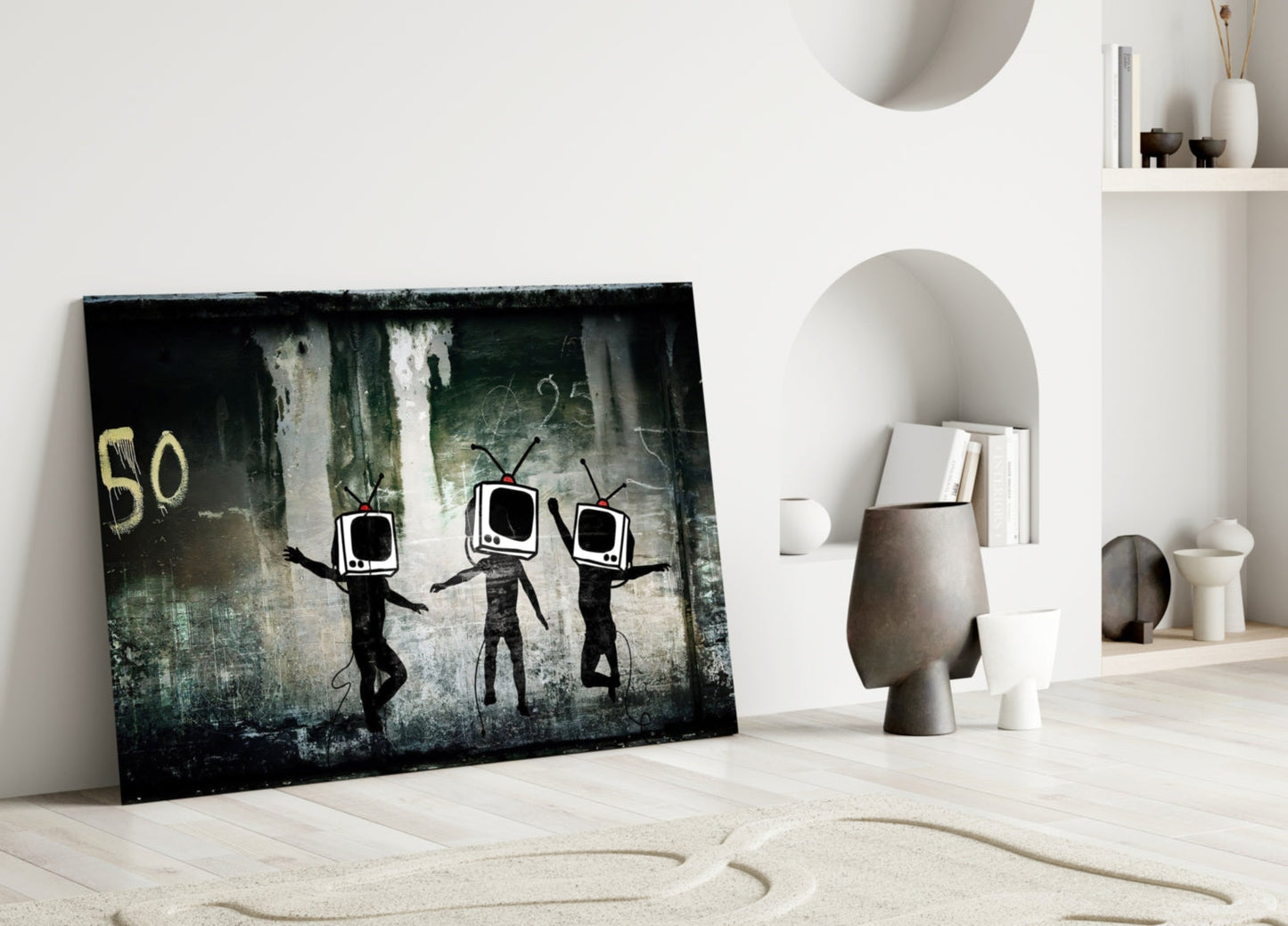 Glass art leaning against white wall depicting three black stick figures with television screens for heads against textured dark background.
