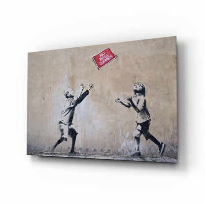 Angled view of glass art canvas showing stenciled children reaching toward red "No Ball Games" sign on textured beige wall.