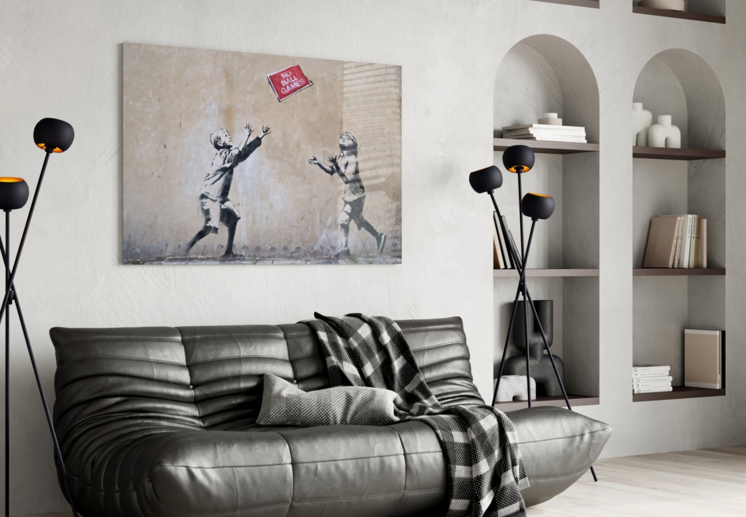 Black floor lamp with spherical shade displayed in modern living room beside gray leather sofa and wall art.