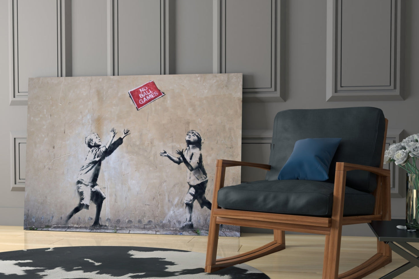 Large canvas print of stenciled children playing catch with "No Ball Games" sign displayed in modern room setting next to wooden chair.