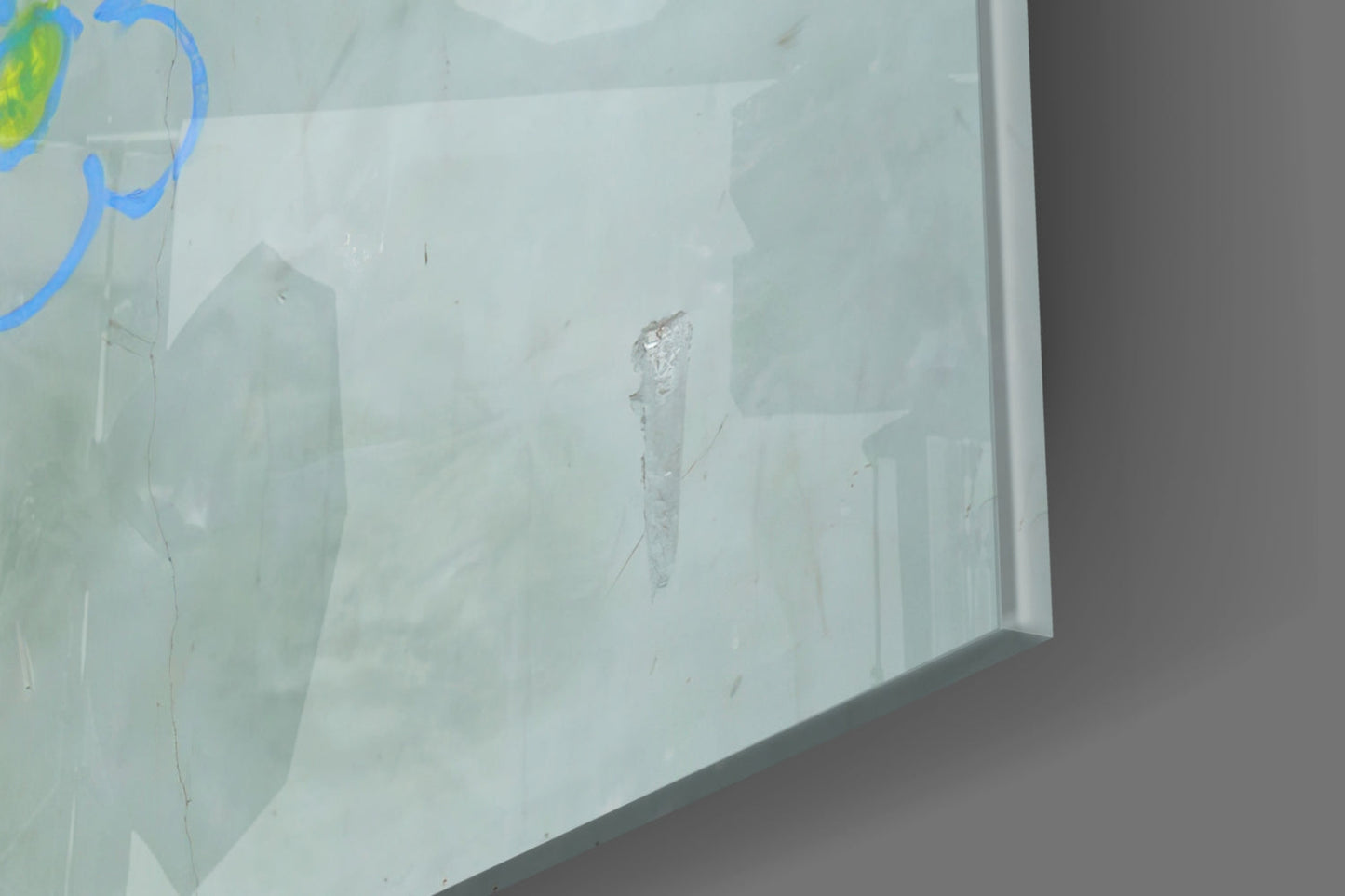 Close-up of frosted glass panel showing etched figure and blue curved lines detail.