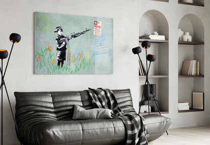 Banksy-style glass art depicting stenciled child figure with gun surrounded by colorful childish drawings, displayed above black leather sofa in modern living room.