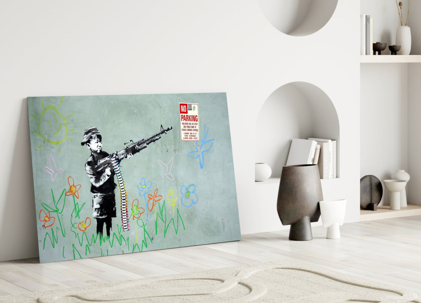 Glass art print leaning against white wall featuring stenciled child figure holding rifle with colorful childlike drawings of flowers and sun on pale blue background.