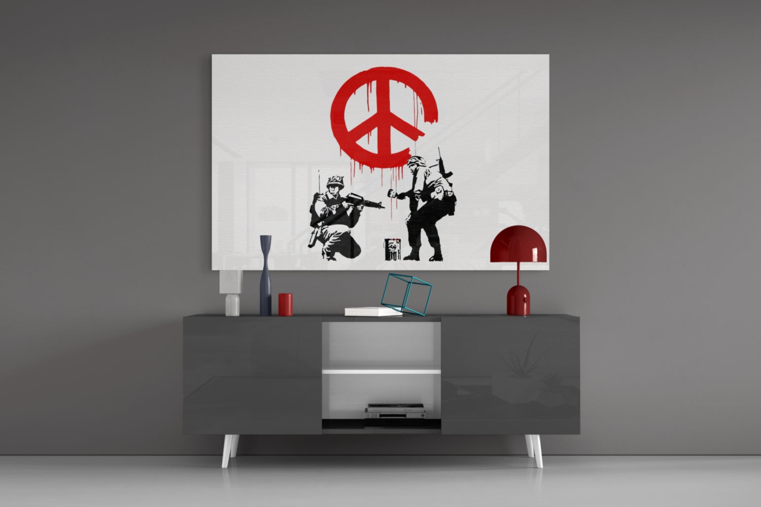 Red and black peace symbol glass art with soldiers displayed above modern gray media console in minimalist interior setting.