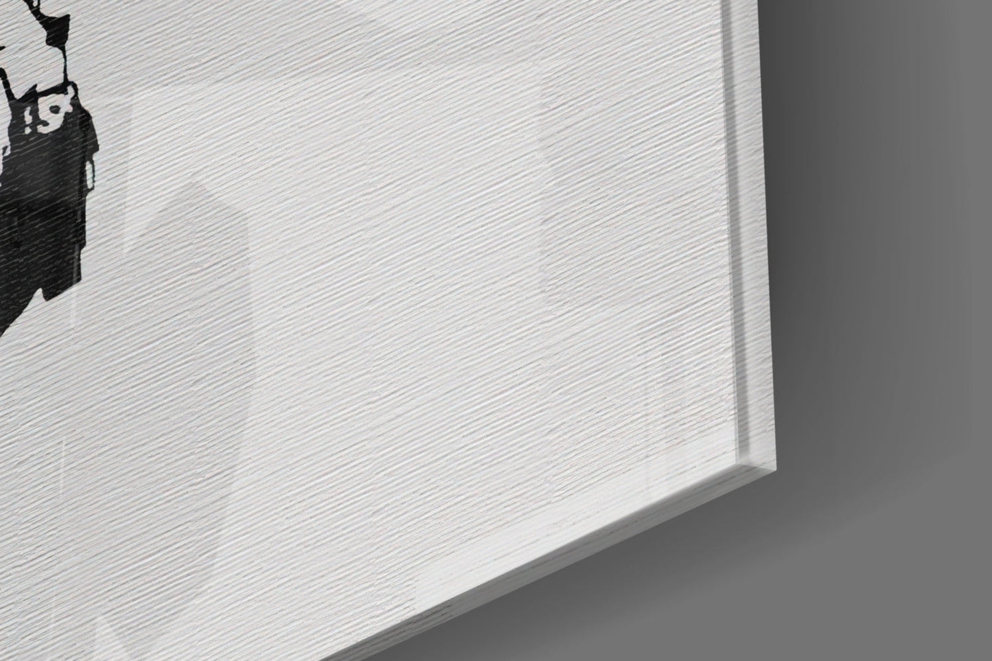 Close-up angled view of white textured glass art piece with black silhouette design in corner.