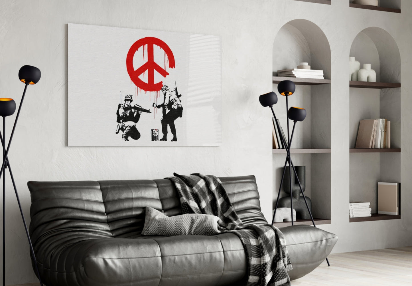 Modern living room featuring black leather sofa with glass wall art displaying red peace symbol and black stenciled figures.