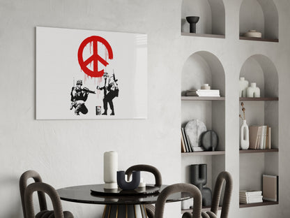 Red peace symbol with black stenciled soldiers hanging from rope displayed above round black dining table in modern interior.