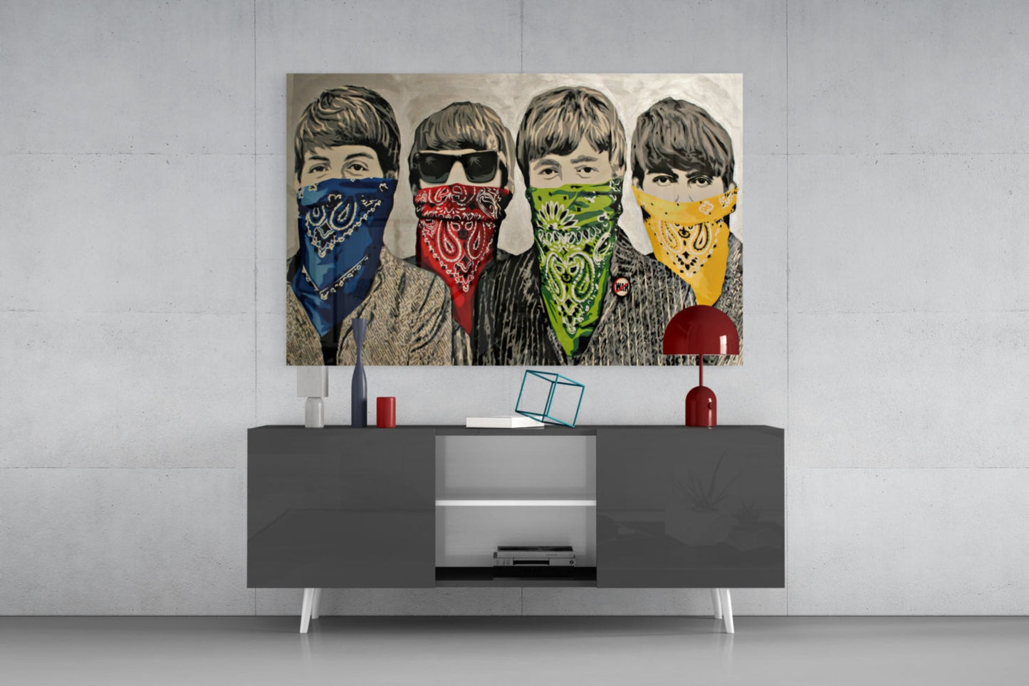 Four illustrated men with 1960s-style haircuts wearing colored bandanas in blue, red, green, and yellow displayed above a modern gray media console.