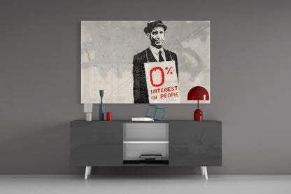 Modern living room setup with a gray media console displaying a black and white street art print featuring a suited figure holding a red sign reading "0% Interest in People.