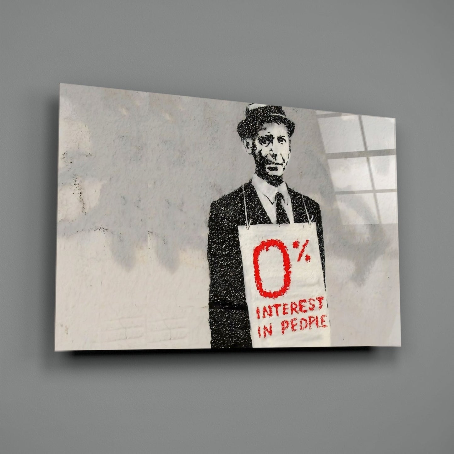Stenciled street art on glass showing a suited man holding a sign reading "0% INTEREST IN PEOPLE" in red text.