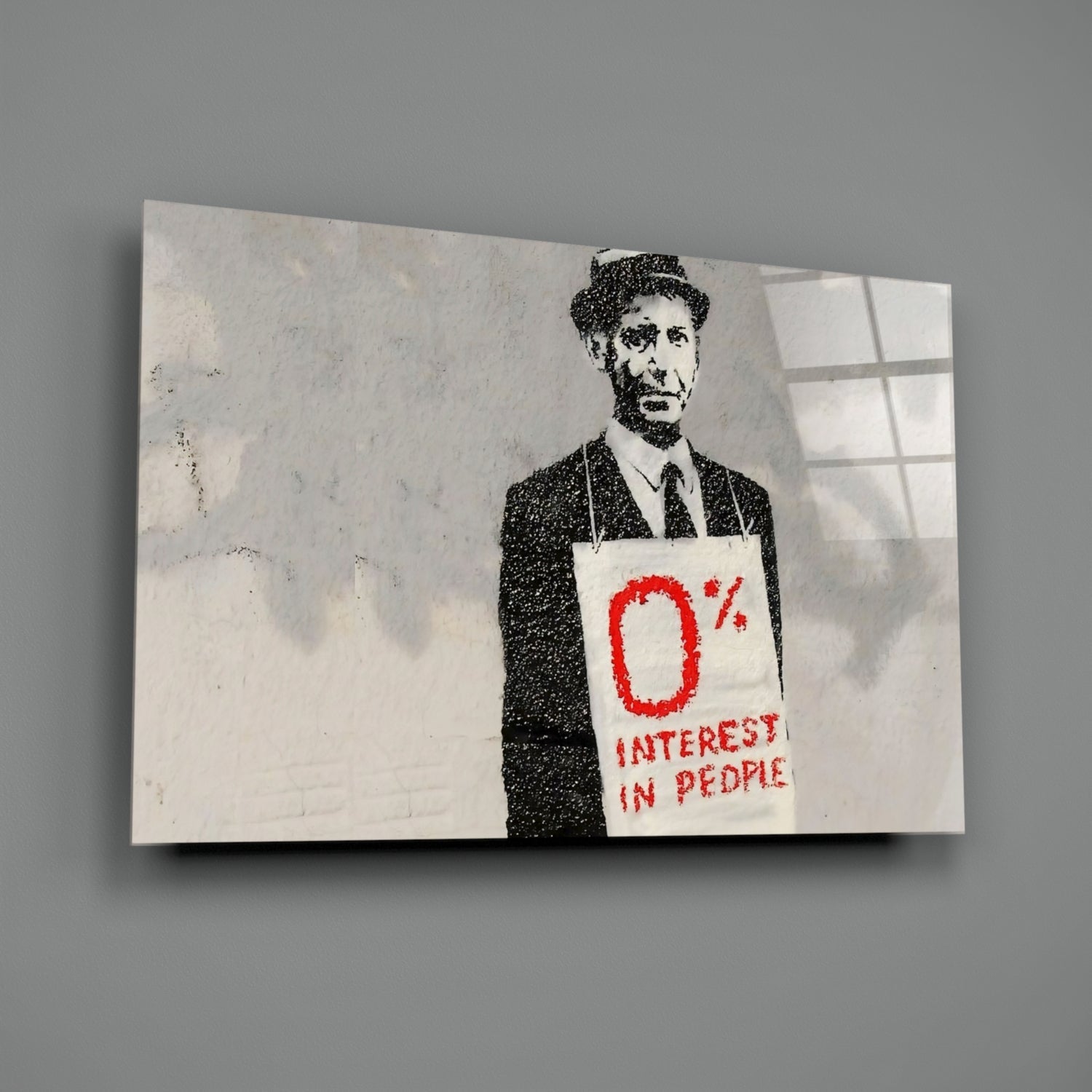 Stenciled street art on glass showing a suited man holding a sign reading "0% INTEREST IN PEOPLE" in red text.