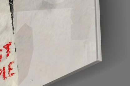 Close-up of white fabric with red cross-stitch pattern and black thread detail against gray background.