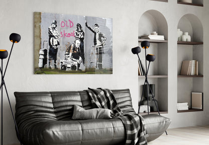 Black and white street art canvas with "OLD skool" text displayed above gray leather sofa in modern living room.