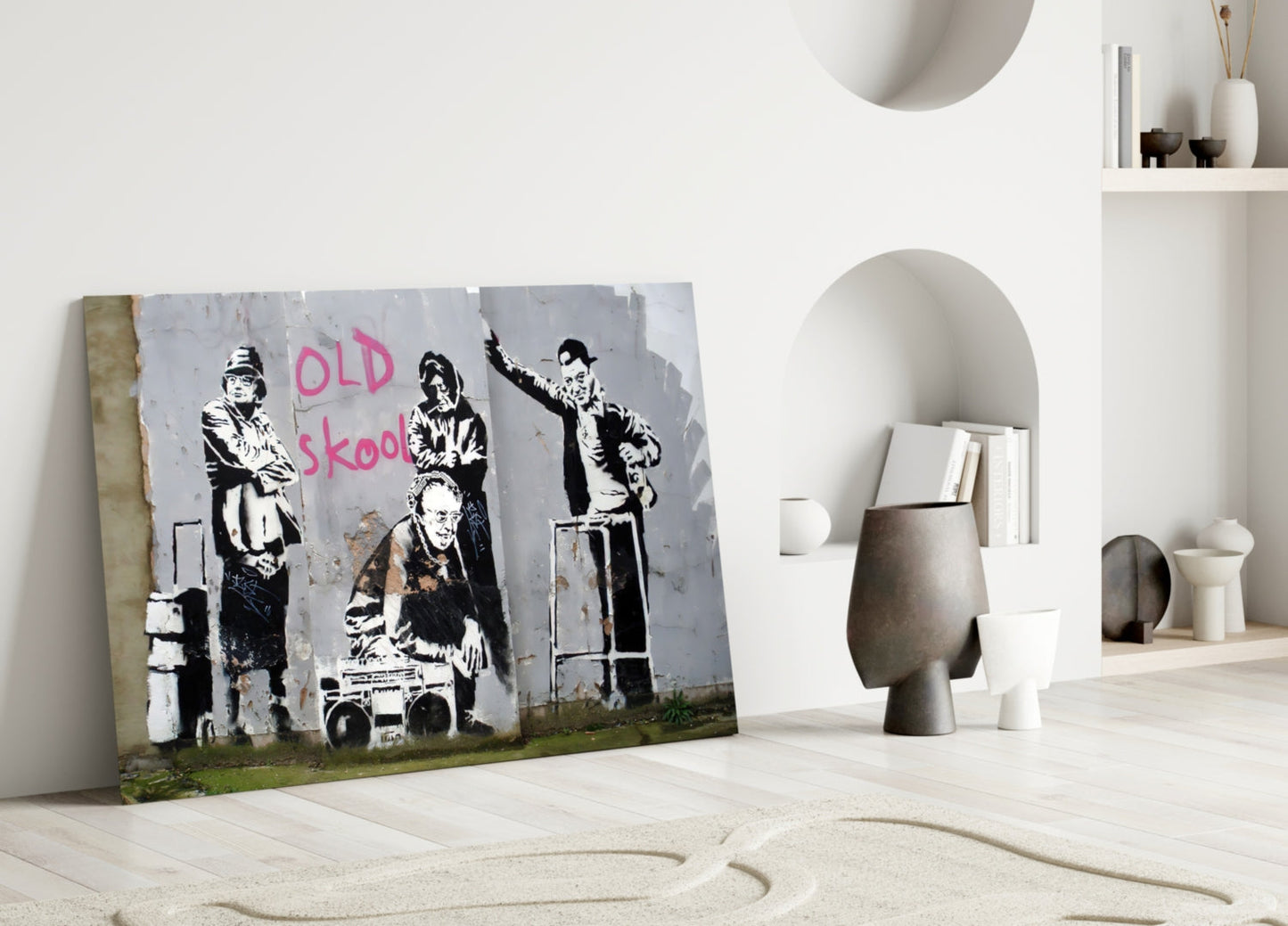 Street art glass panel leaning against white wall in minimalist interior, featuring black stenciled figures and pink "OLD skool" text.