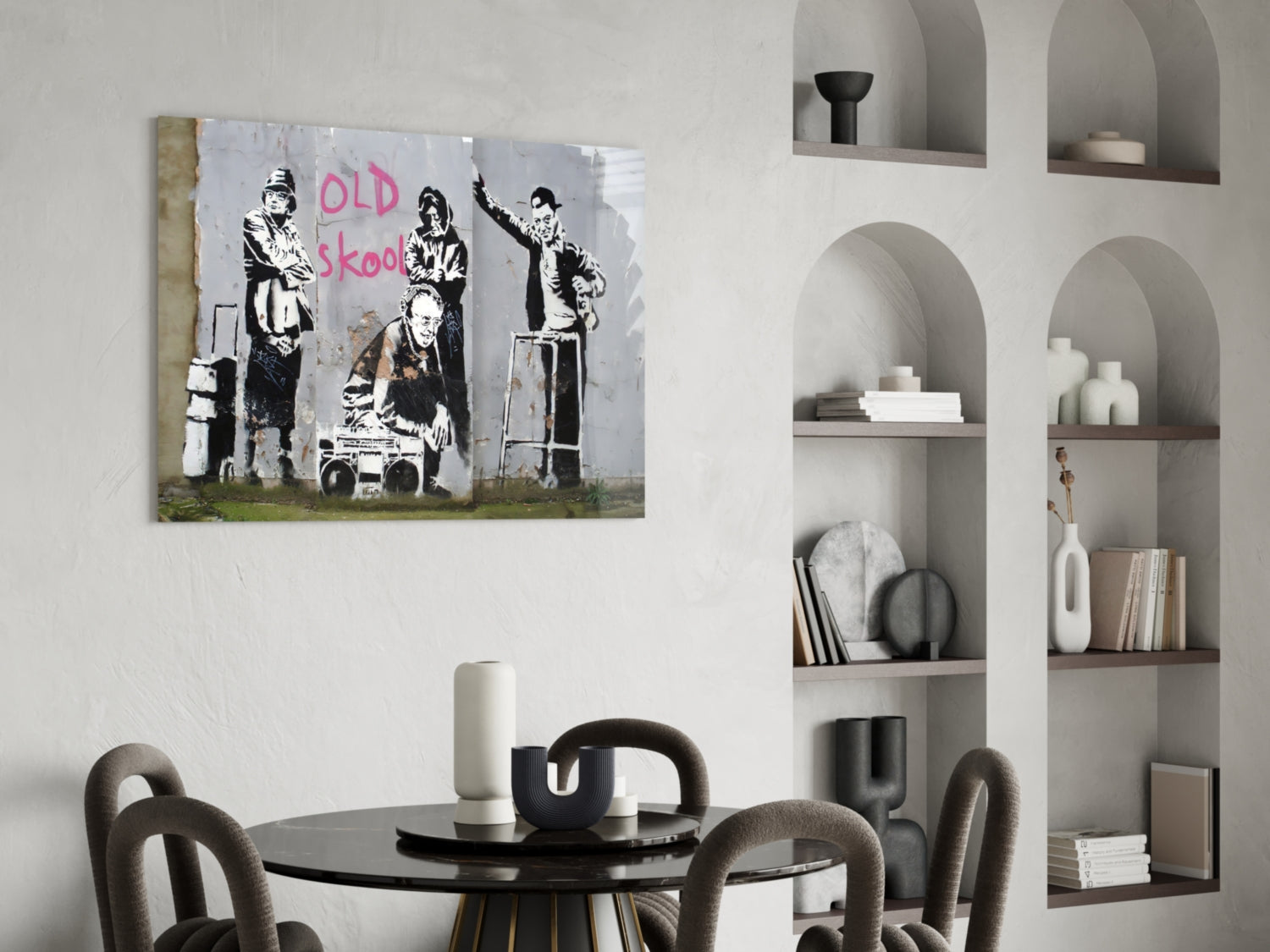 Street art canvas featuring stenciled figures with "OLD skool" text in pink spray paint displayed above round dining table.