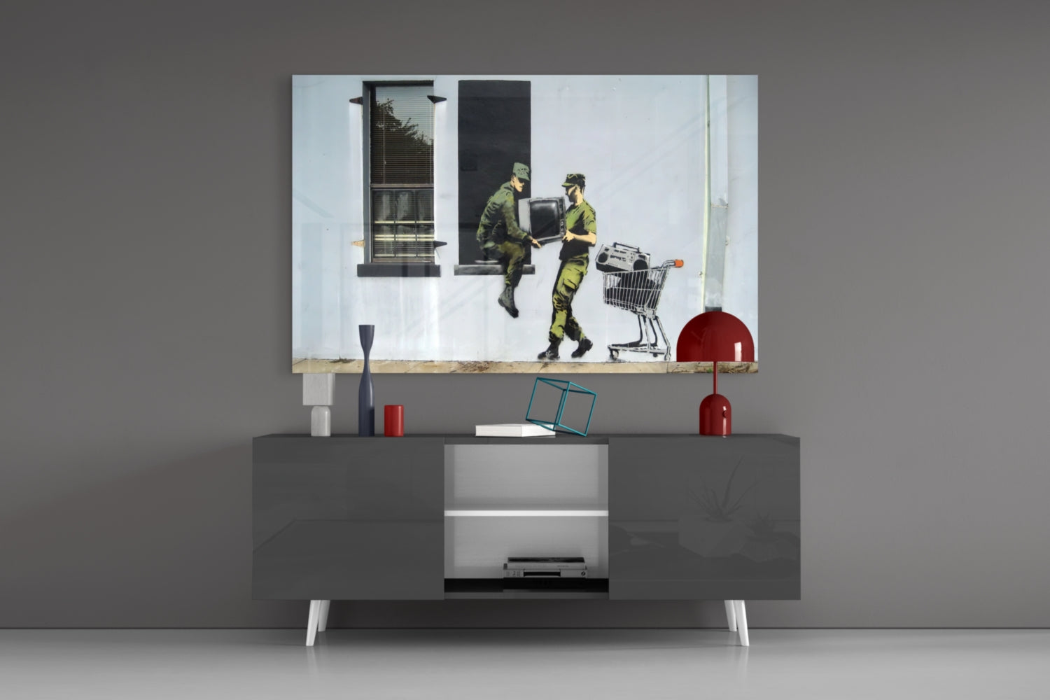 Soldier glass art depicting two military figures in camouflage exchanging a box beside a shopping cart, displayed above a modern gray media console.