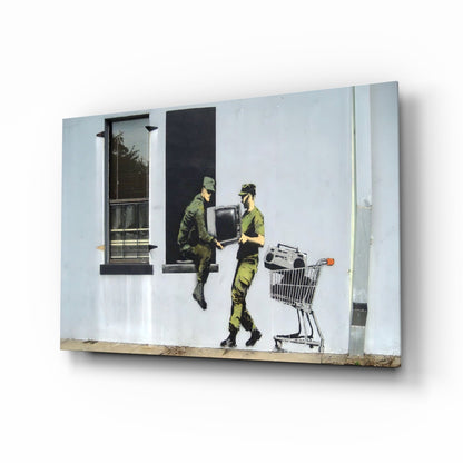 Glass art panel showing two camouflaged soldiers exchanging a television and shopping cart against white wall with windows.
