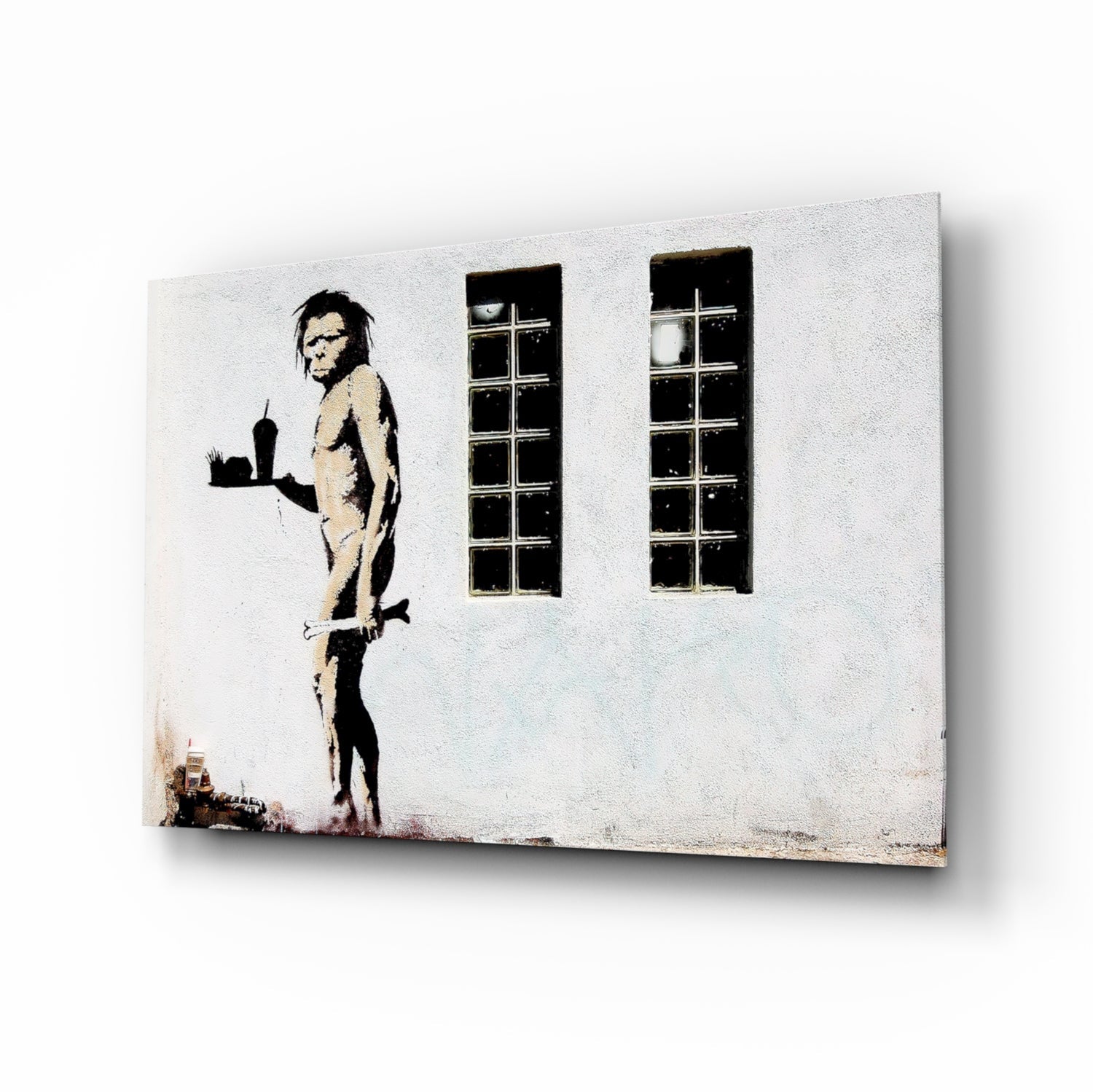 Canvas print of stenciled figure holding cityscape, standing beside two tall windows on white wall.
