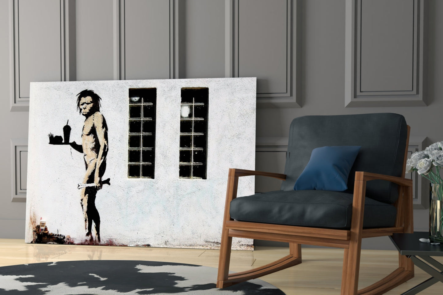Large canvas artwork depicting a stenciled neanderthal figure holding a cityscape, displayed in modern interior with wooden chair.