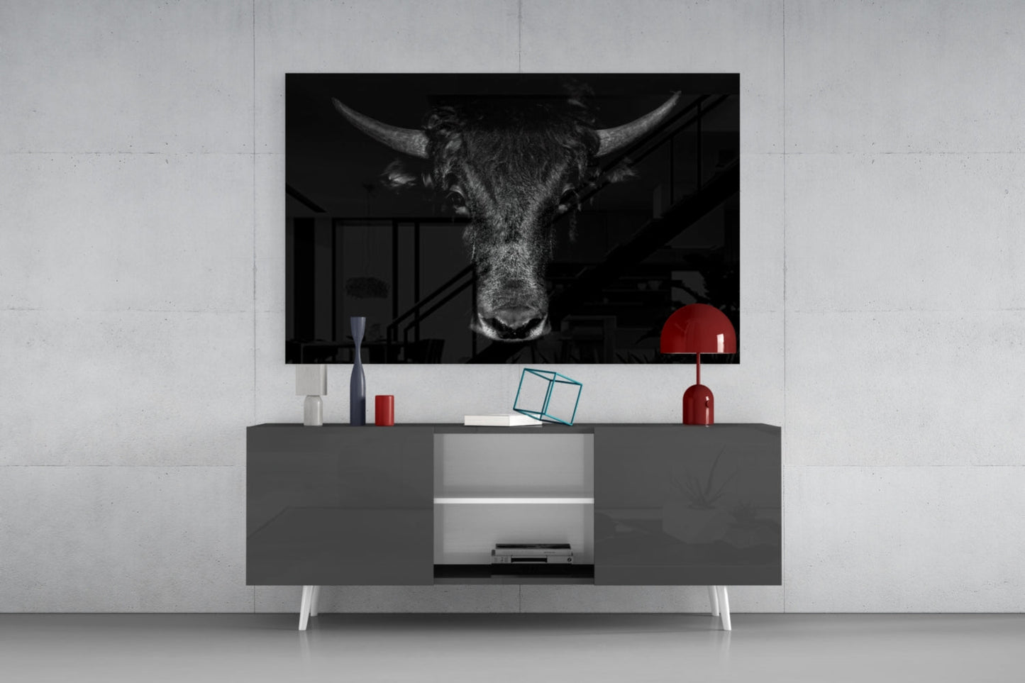 Black and white buffalo head art displayed on wall above gray media console with red lamp and decorative objects.
