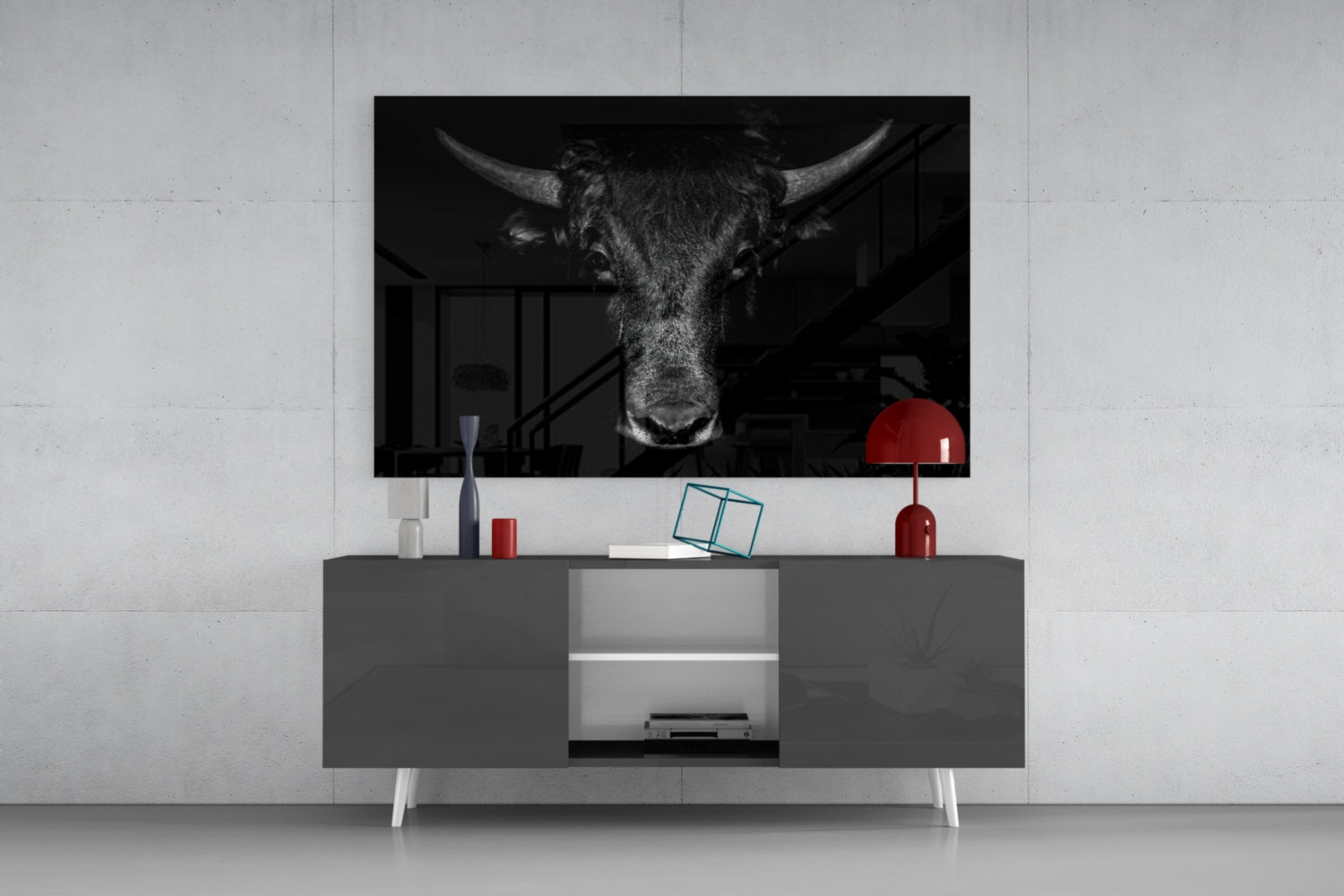 Black and white buffalo head art displayed on wall above gray media console with red lamp and decorative objects.