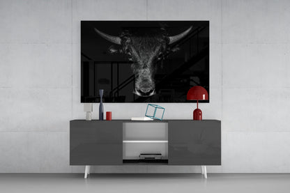 Black and white buffalo head art displayed on wall above gray media console with red lamp and decorative objects.