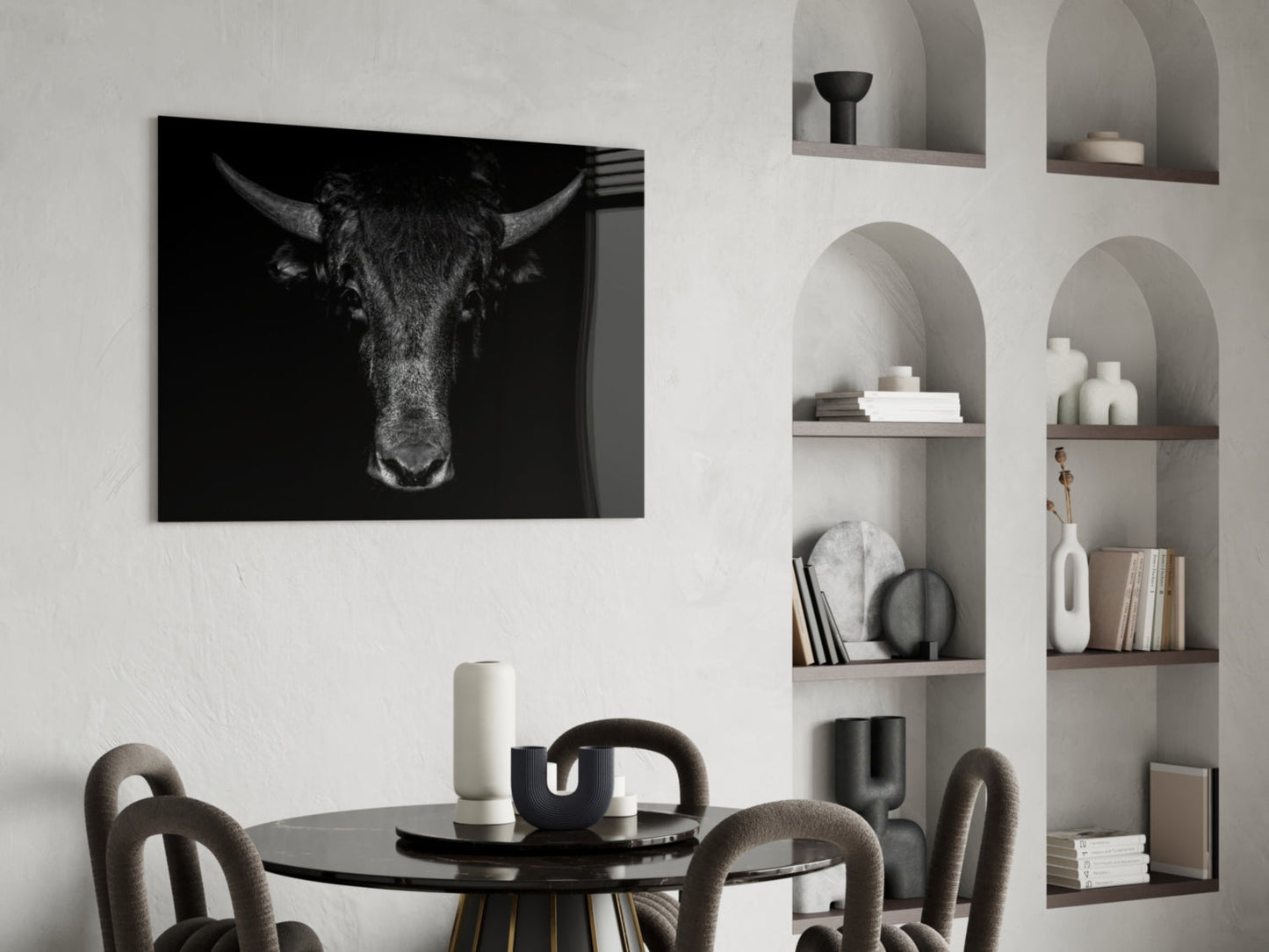 Black and white buffalo portrait glass art displayed above a round black dining table with upholstered chairs.