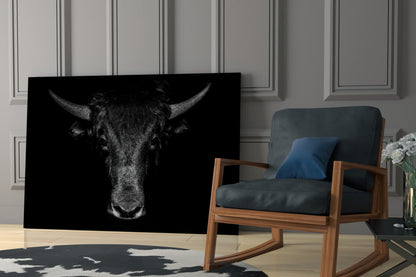 Black and white buffalo head portrait glass art displayed in modern living room beside wooden chair with blue cushion.
