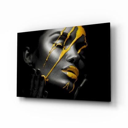 Monochromatic portrait of a woman's face in profile with vibrant yellow paint strokes across her features, displayed on glass art.