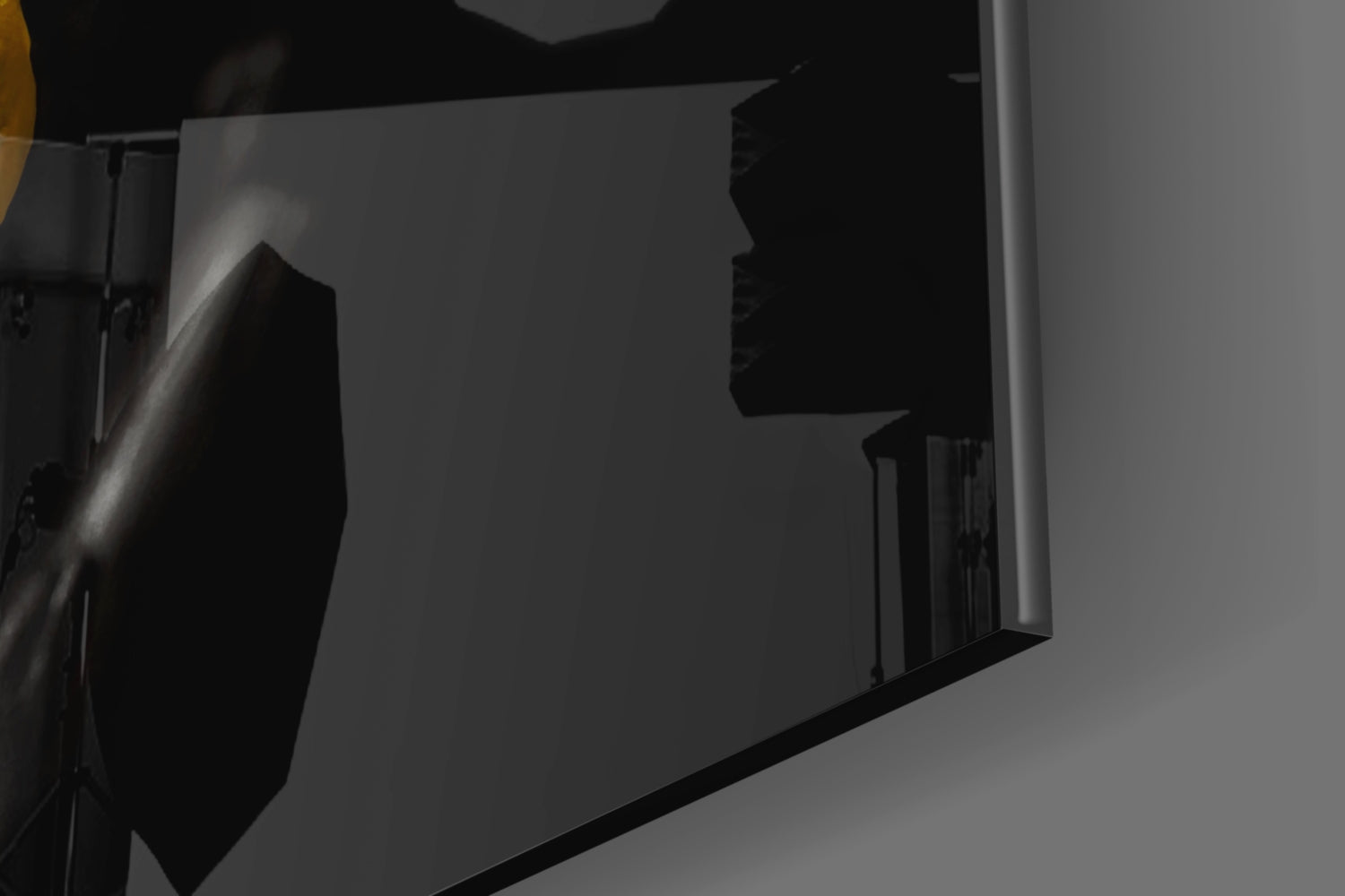 Close-up of yellow paint glass art piece showing layered glass sheets and black metal frame against gray background.