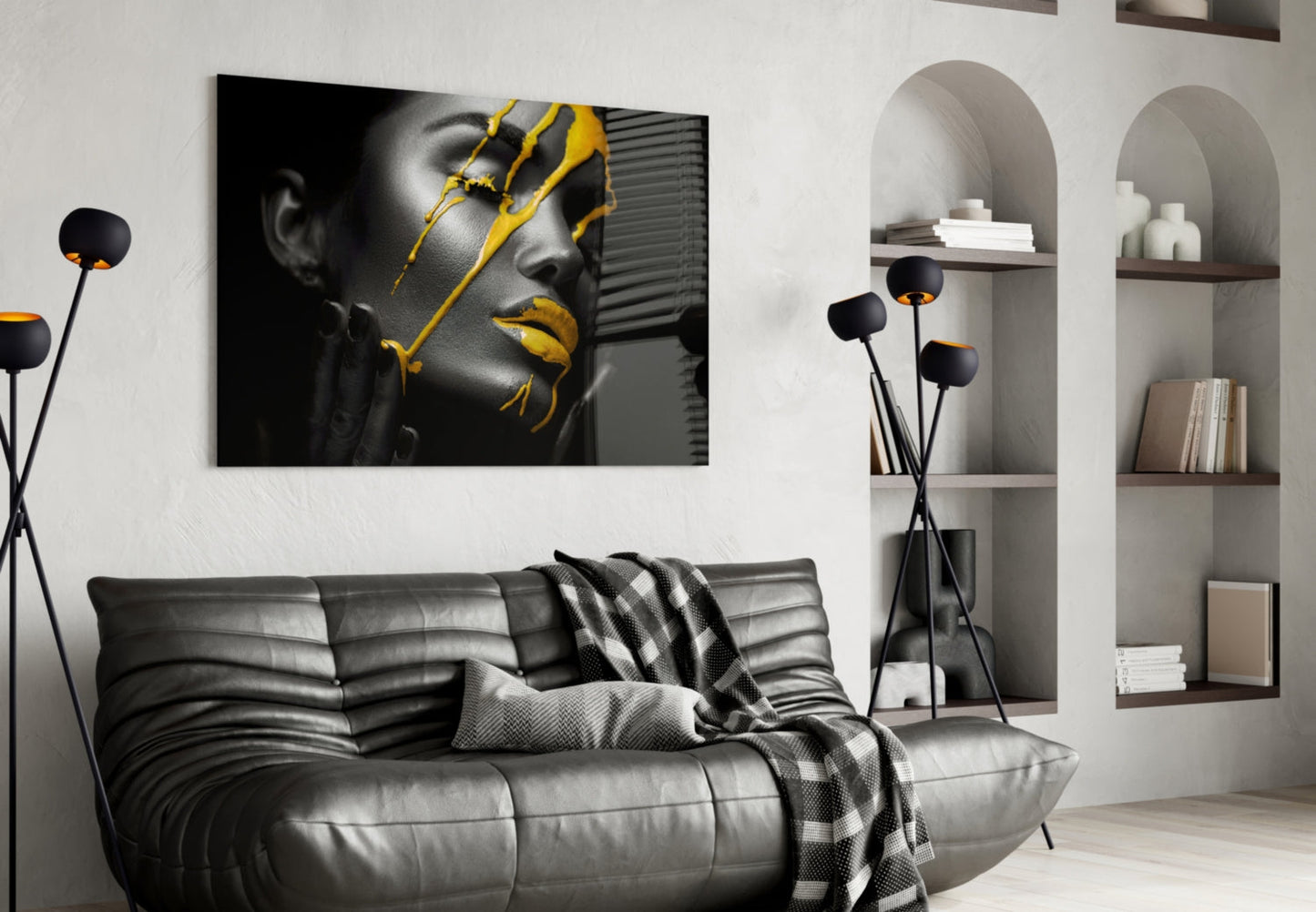 Yellow paint glass art featuring grayscale portrait with gold accents displayed above black leather sofa in modern living room.