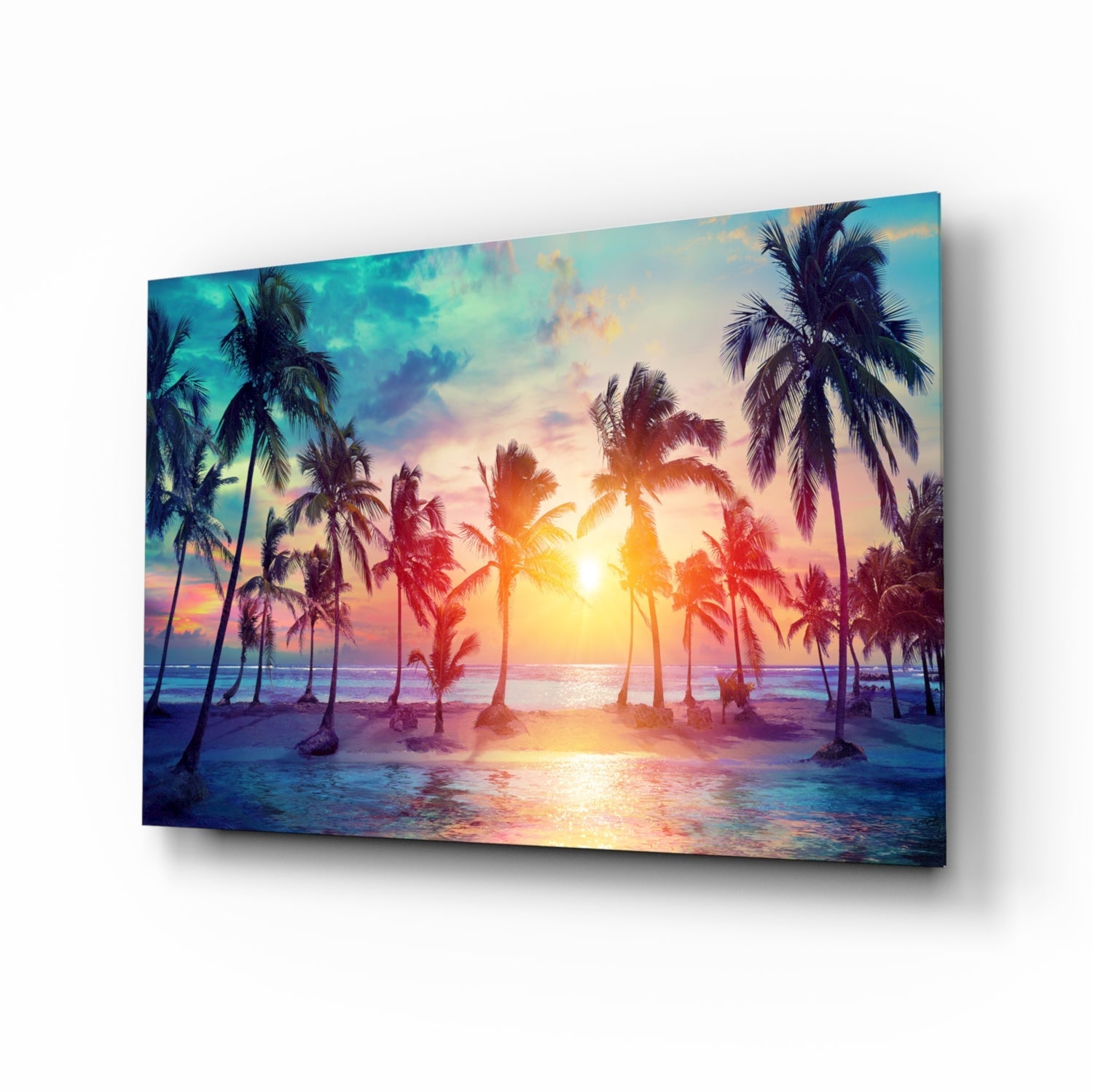 Angled view of glass art panel displaying tropical beach sunset with palm trees, golden sun, pink and blue sky, and ocean water reflection.