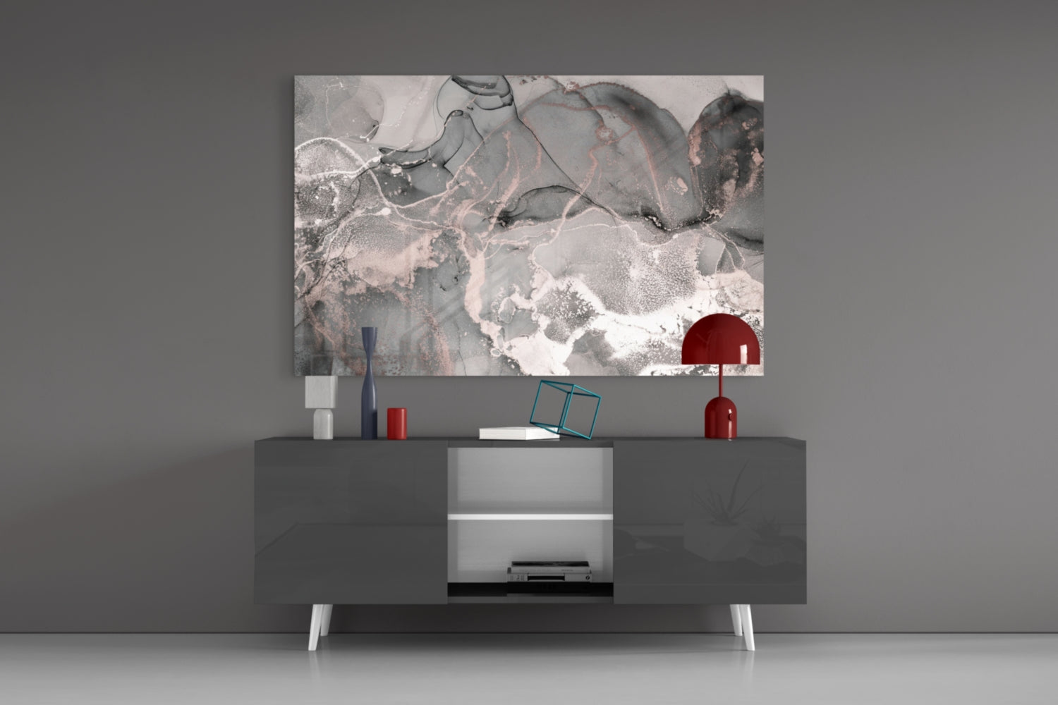Modern living room setup displaying abstract pink and gray glass art above dark media console with red lamp and accessories.