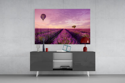 Glass art print of purple lavender field with hot air balloon displayed above modern gray media console in contemporary living room setting.