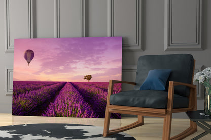 Curved glass art panel displaying purple lavender field with hot air balloon and pink sunset sky, displayed in modern room setting beside wooden chair.