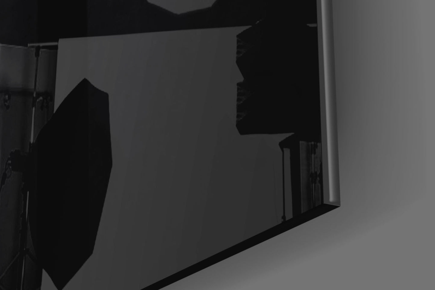 Silhouetted view of a circular sight glass and rectangular panel mounted on a wall, photographed at an angle against gray background.