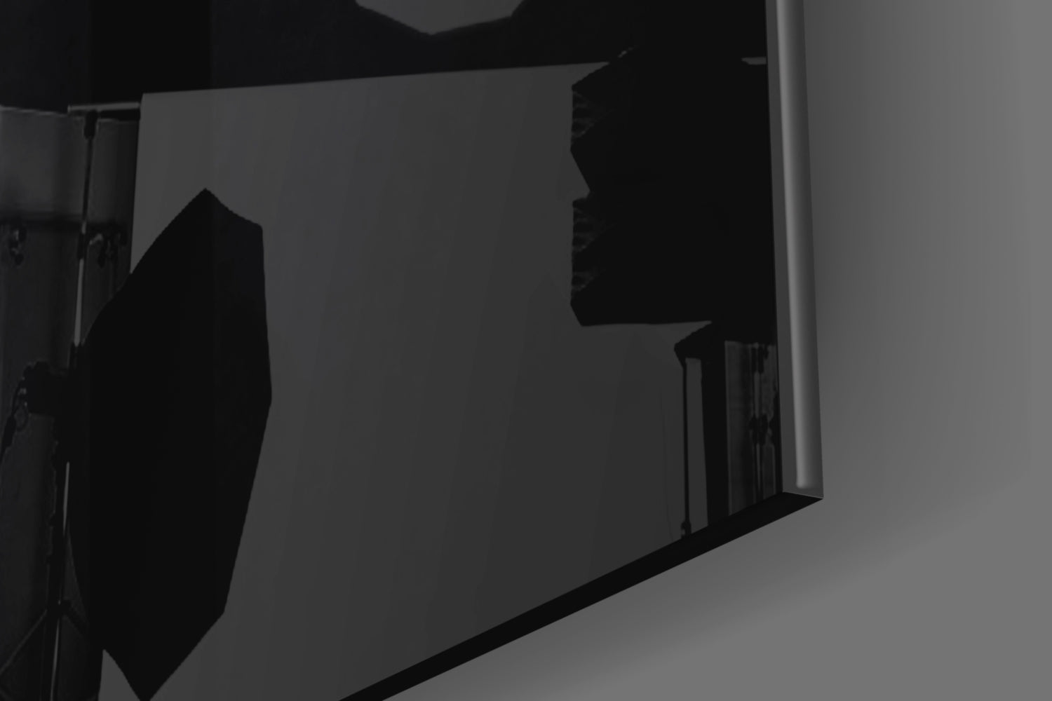 Silhouetted view of a circular sight glass and rectangular panel mounted on a wall, photographed at an angle against gray background.