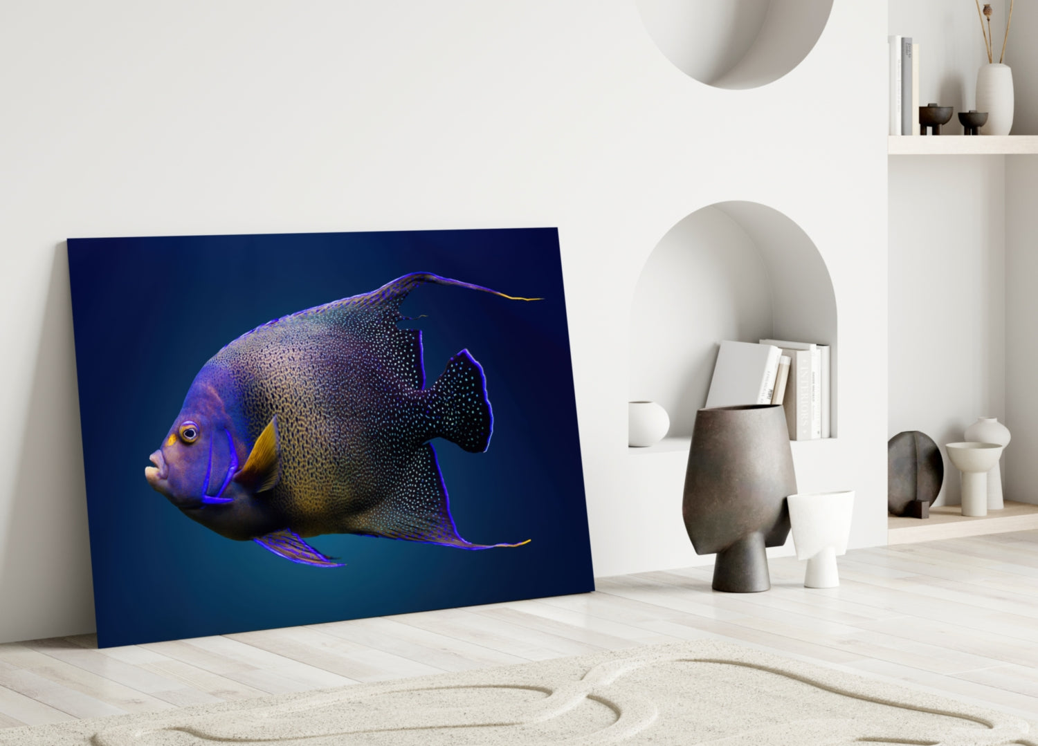 Vibrant Queen Angelfish glass art leaning against white wall in minimalist room setting with decorative objects.