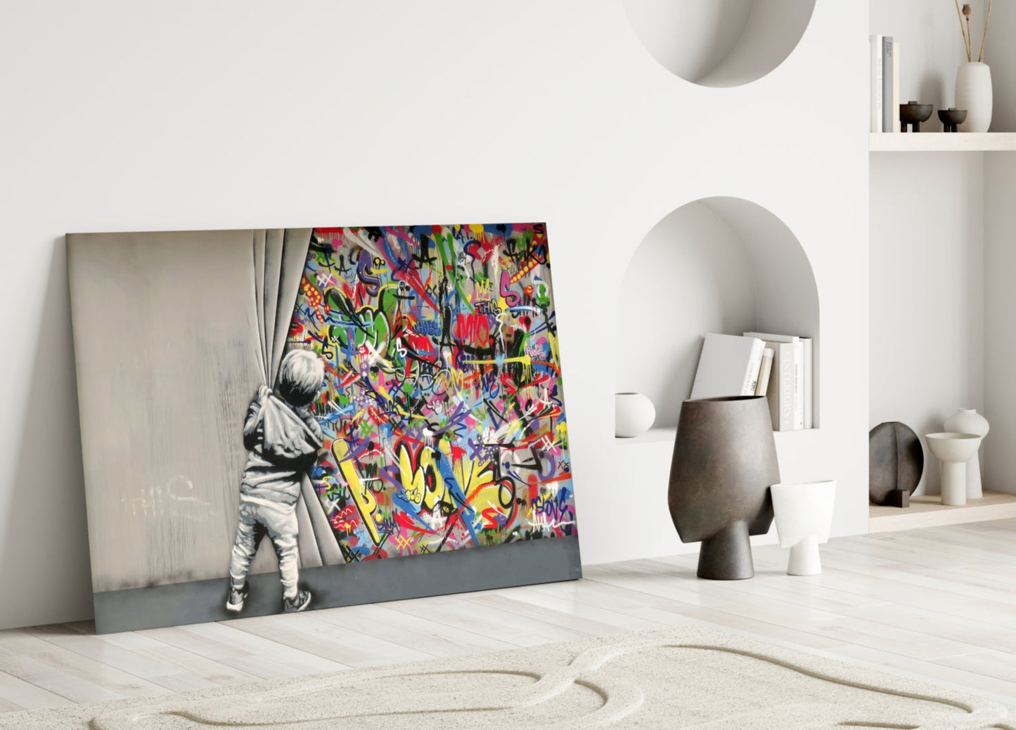 Glass art leaning against white wall displays child pulling colorful graffiti curtain beside minimalist home décor.