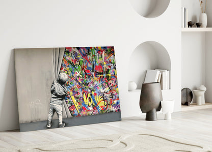 Glass art leaning against white wall displays child pulling colorful graffiti curtain beside minimalist home décor.