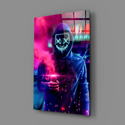 Angled view of glass art panel displaying neon-glowing hooded figure with X-eyes and stitched mouth against vibrant magenta and blue backgrounds.