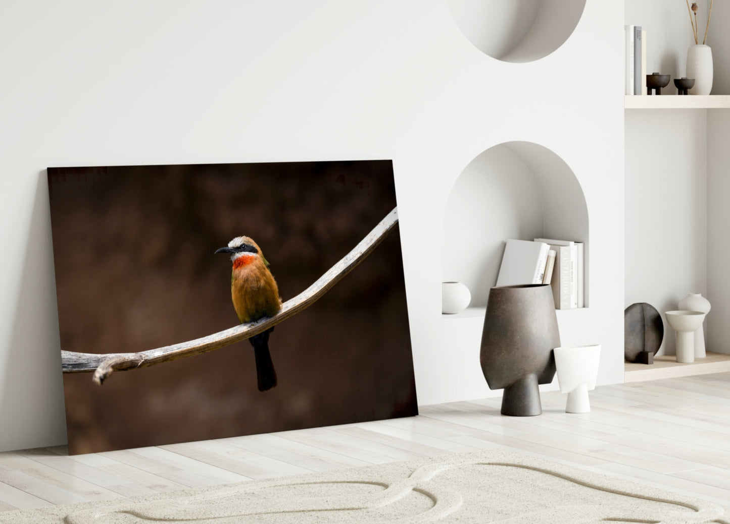 Colorful bee-eater bird perched on white branch against dark background, displayed as framed glass art leaning against white wall.